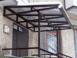Козырек на опорах над входом в подъезд дома